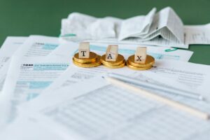 Gros plan sur des formulaires fiscaux, des reçus et des pièces symbolisant la comptabilité financière et les impôts.