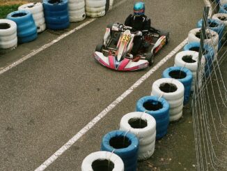 un homme conduisant un kart avec des pneus sur le bord d'une route