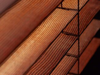 Lames de bois et grille métallique sous lumière tamisée