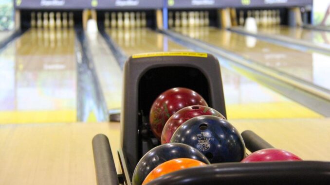 Balle de bowling dans le porte-balles, voie et quilles visibles