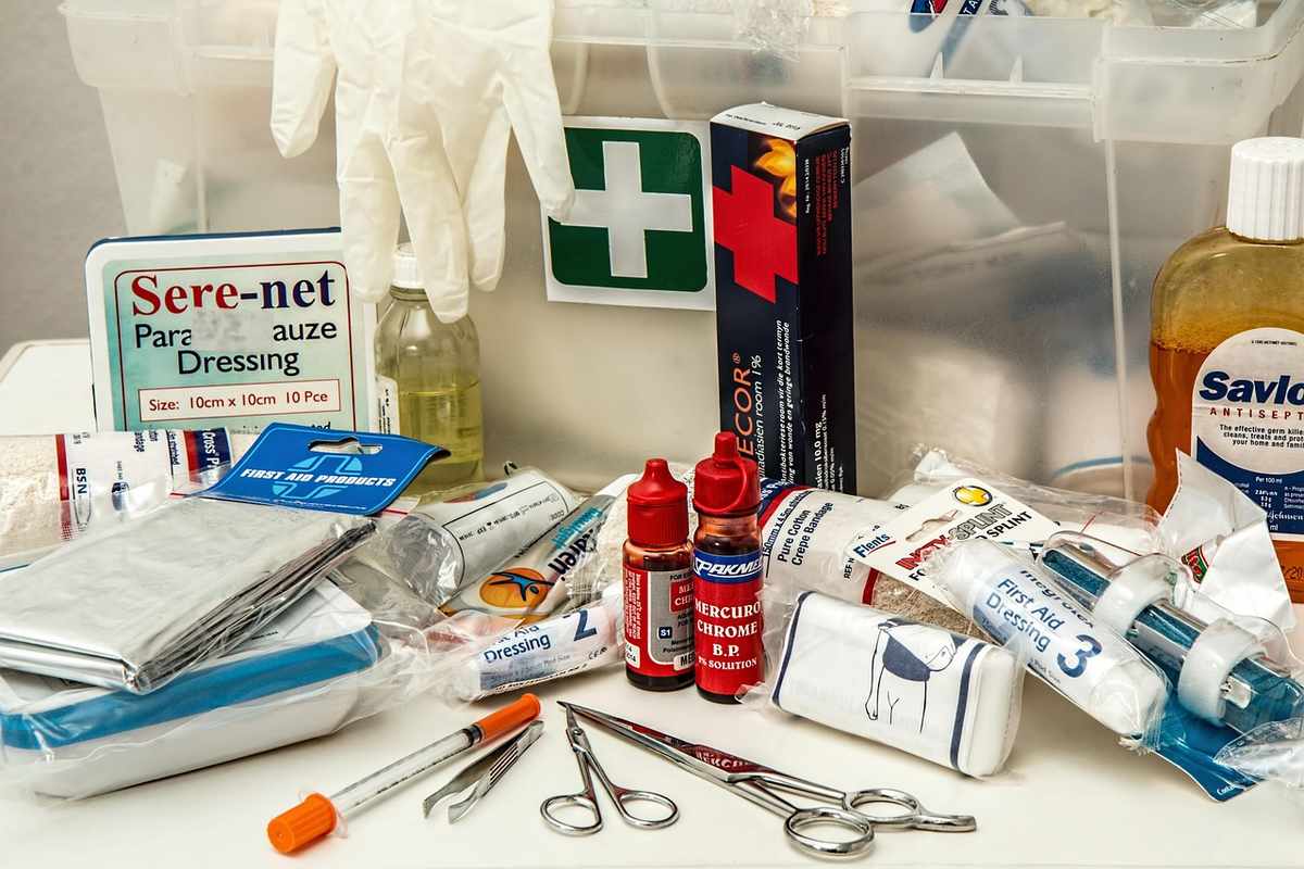 Vue d'une trousse de premiers secours contenant pansements, ciseaux, seringues et gants