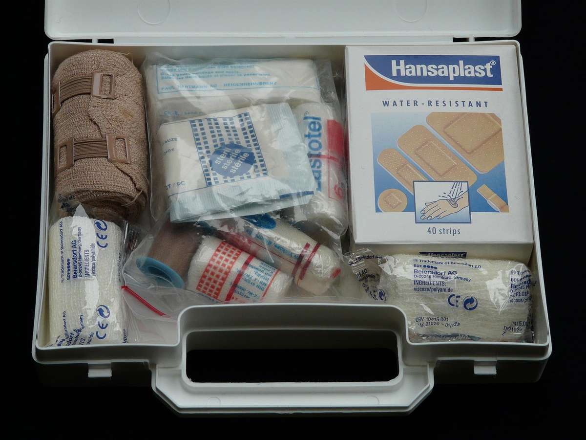 Photo d'une trousse de secours contenant pansements, bandages, compresses et Hansaplast