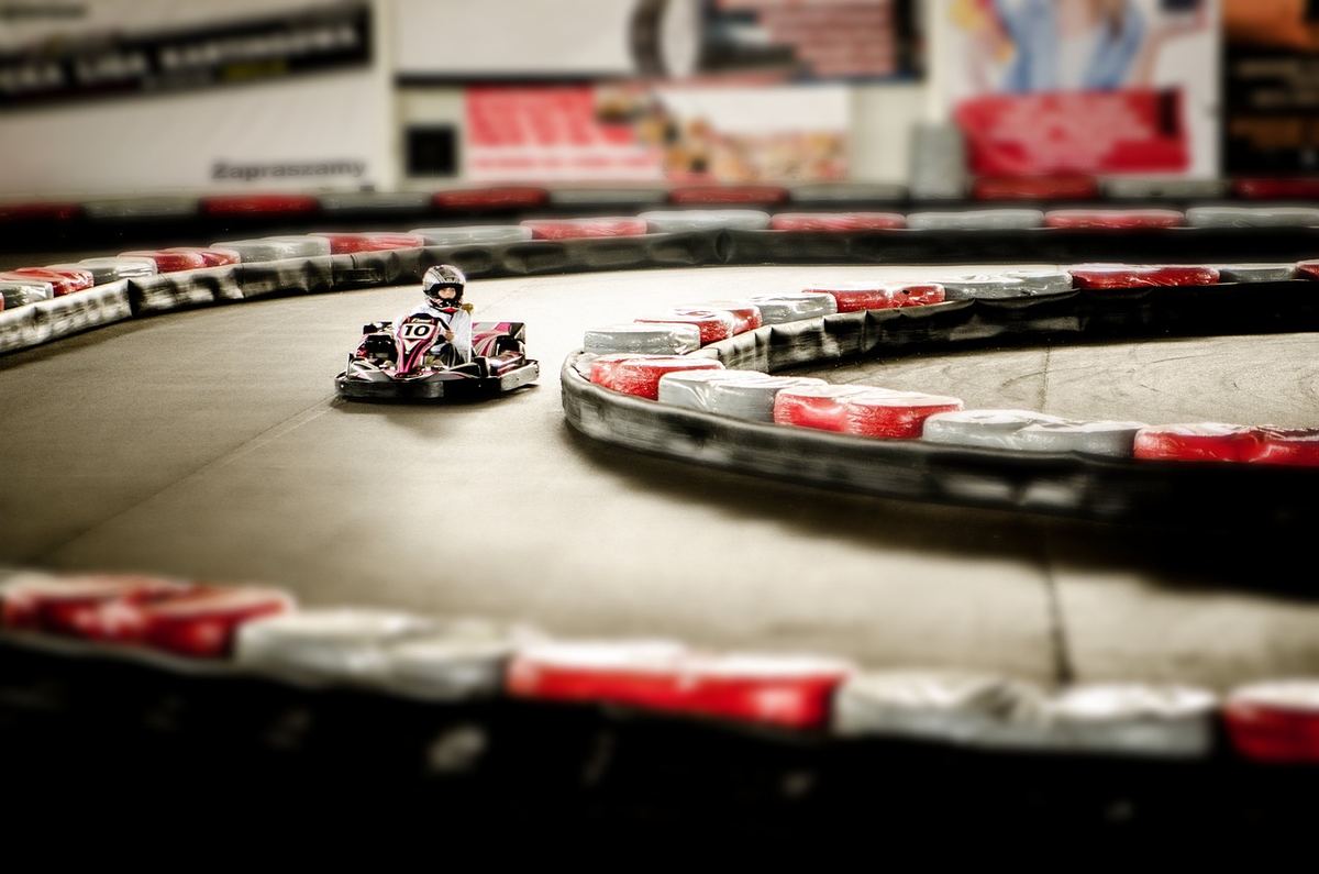 Un kart miniature tourne rapidement sur un circuit intérieur