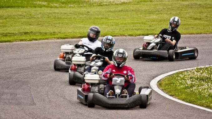 Quatre conducteurs en karting tournent sur un virage de piste