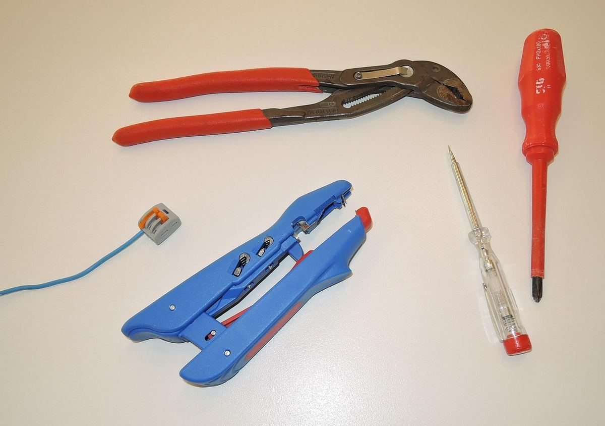Outils de bricolage et fil bleu sur une surface blanche