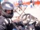 Un homme en karting, casque noir, mains sur le volant, prêt à conduire